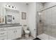Clean bathroom featuring tiled stand up shower, granite countertop, and white cabinets at 10560 Waco St, Commerce City, CO 80022