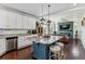 Beautiful kitchen with white cabinets, an island with stools, and an open view to the living room at 10560 Waco St, Commerce City, CO 80022