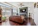 Cozy living room with fireplace, large windows, ceiling fan, and dark wood floors at 10560 Waco St, Commerce City, CO 80022