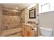 Bathroom featuring a walk-in tiled shower with a bench, vanity, and toilet at 1740 Territory Cir, Parker, CO 80138