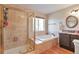 Elegant bathroom showcasing a glass shower, soaking tub, and stylish vanity with hardwood floors at 1740 Territory Cir, Parker, CO 80138