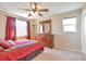 Charming bedroom with rich red tones, complemented by a wooden dresser and ample natural light at 1740 Territory Cir, Parker, CO 80138