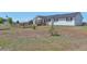 Home's front yard with a wooden fence and mature trees under a clear blue sky at 1740 Territory Cir, Parker, CO 80138