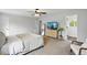 A well-lit bedroom featuring plush carpet, a ceiling fan, and a modern dresser with a TV at 7868 Downing St, Denver, CO 80229