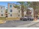 Tan apartment building with large shade trees and marked parking spaces at 9700 E Iliff Ave # C20, Denver, CO 80231