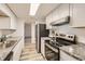 Modern kitchen featuring stainless steel appliances, granite countertops, and white cabinetry at 9700 E Iliff Ave # C20, Denver, CO 80231