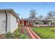 Exterior shot showcases a backyard with vibrant lawn, brick path, and inviting covered porch at 1011 Uvalda St, Aurora, CO 80011