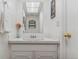 Clean and well-lit bathroom with a white vanity, decorative mirror, and minimalist decor at 12520 W Virginia Ave, Lakewood, CO 80228