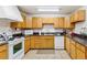 Functional kitchen with light wood cabinets, granite countertops, and modern white appliances at 12520 W Virginia Ave, Lakewood, CO 80228