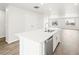 Bright kitchen island with stainless dishwasher and sink with white countertops and view to living room at 14422 Pansy Loop, Morrison, CO 80465