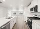 Modern kitchen boasts stainless appliances, quartz countertops, and hardwood floors flowing into the living space at 14422 Pansy Loop, Morrison, CO 80465