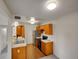 Galley kitchen featuring stainless steel refrigerator, black range, and wooden cabinetry at 1094 S Dearborn St # 301, Aurora, CO 80012