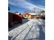 A snow-covered backyard featuring a brick house, a red shed, and a sliding glass door at 2060 S Washington St, Denver, CO 80210