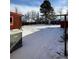 Snowy backyard featuring outbuildings, an AC unit and glimpses of neighboring houses beyond a bare, wintry tree line at 2060 S Washington St, Denver, CO 80210