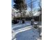 Snowy backyard featuring a chain link fence and three trash cans and one metal can in the distance at 2060 S Washington St, Denver, CO 80210