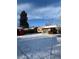 A snow-covered backyard featuring a brick house, a red shed, and a sliding glass door at 2060 S Washington St, Denver, CO 80210