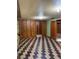 View of finished basement area with wood paneling, unique floor, and multiple doorways at 2060 S Washington St, Denver, CO 80210