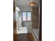 Bathroom featuring a vanity, a window and a tub with marble-look tiling at 2060 S Washington St, Denver, CO 80210