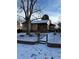 Charming single-story home featuring a brick facade, red roof, and snow-covered front yard with mature trees at 2060 S Washington St, Denver, CO 80210