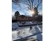 Charming single-story home with brick accents, and a red roof, surrounded by mature trees in a snow-covered yard at 2060 S Washington St, Denver, CO 80210