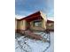 Close-up of the home's front porch, showcasing brick accents, a red roof, and metal railings with snow at 2060 S Washington St, Denver, CO 80210