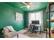 Serene bedroom with dark teal walls, window, and a workspace at 9506 Castle Ridge Cir, Highlands Ranch, CO 80129