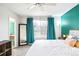 Bright bedroom with teal walls, large window, and ensuite bathroom at 9506 Castle Ridge Cir, Highlands Ranch, CO 80129