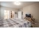 Spacious bedroom with a plaid comforter, unique side table, and multiple closets at 7108 Morrison Dr, Frederick, CO 80530