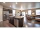 Open concept kitchen with a large island, stainless steel appliances, and seamless flow into the living area at 7108 Morrison Dr, Frederick, CO 80530