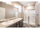Bathroom featuring double sinks, a large mirror, and a walk-in shower at 7108 Morrison Dr, Frederick, CO 80530