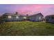 Backyard view of home with grassy lawn, wooden deck, storage shed, and colorful sunset sky at 7716 Shenandoah Dr, Elizabeth, CO 80107
