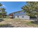 Backyard view of a two-story home with a wood deck and a gravel and grass-covered yard at 7716 Shenandoah Dr, Elizabeth, CO 80107