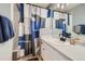 Bathroom featuring a white vanity with a black faucet and a shower with a blue and grey curtain at 7716 Shenandoah Dr, Elizabeth, CO 80107