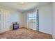 Bedroom features a large window with patterned curtains, light-grey paint, and neutral-colored carpet at 7716 Shenandoah Dr, Elizabeth, CO 80107