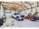 Spacious garage featuring tall ceilings, white walls, a truck, and an orange tractor at 7716 Shenandoah Dr, Elizabeth, CO 80107