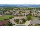 Aerial view of a luxury home with a circular driveway surrounded by lush landscaping and neighborhood at 2378 Plumb Pl, Erie, CO 80516