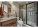 Modern bathroom with granite countertops, dark fixtures, and a glass-enclosed walk-in shower at 2378 Plumb Pl, Erie, CO 80516