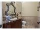 Elegant powder room with marble countertop, stylish mirror, and tiled accent wall with modern fixtures at 2378 Plumb Pl, Erie, CO 80516