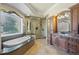 Luxurious bathroom with soaking tub, glass-enclosed shower, and marble countertops on custom cabinetry at 2378 Plumb Pl, Erie, CO 80516