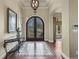 Grand foyer featuring an ornate front door, elegant lighting, and stylish tile flooring at 2378 Plumb Pl, Erie, CO 80516