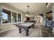 Spacious game room with a pool table, large windows, and an adjacent bar area at 2378 Plumb Pl, Erie, CO 80516