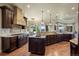 Open-concept kitchen with stone accents, modern appliances, and a seamless flow to the dining area at 2378 Plumb Pl, Erie, CO 80516