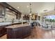 Spacious kitchen with dark wood cabinetry, granite countertops, and stainless steel appliances at 2378 Plumb Pl, Erie, CO 80516