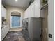 Spacious laundry room with white cabinetry, granite countertops, and modern washer and dryer units at 2378 Plumb Pl, Erie, CO 80516