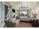 Relaxing main bedroom featuring a cozy fireplace, tray ceilings, and large windows with scenic views at 2378 Plumb Pl, Erie, CO 80516
