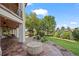 Spacious covered patio with outdoor seating, fire pit, landscaping, and stairs to the upper balcony at 2378 Plumb Pl, Erie, CO 80516