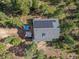 Aerial view of home with solar panels and deck with hot tub and outdoor seating at 6979 Weasel Way, Evergreen, CO 80439