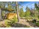 A natural backyard setting featuring a wood storage area and outdoor seating at 6979 Weasel Way, Evergreen, CO 80439