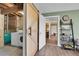 Open basement with sliding barn door, laundry, and view into living space with modern decor and neutral paint at 6979 Weasel Way, Evergreen, CO 80439