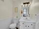 Well-lit bathroom features white vanity, sink and large mirror; wainscoting is visible at 6979 Weasel Way, Evergreen, CO 80439